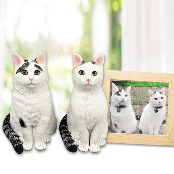 Two white cat bobblehead figurines