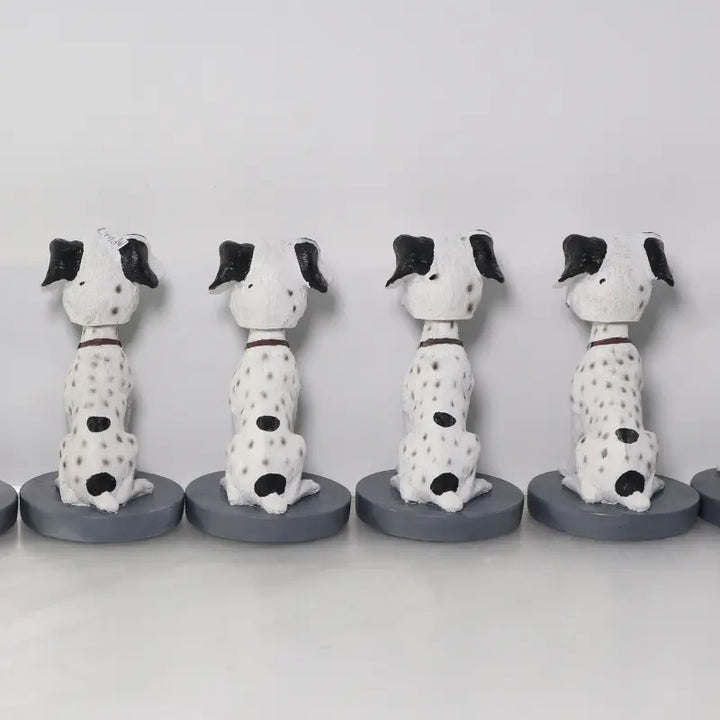 Four ceramic dog figurines with black spots